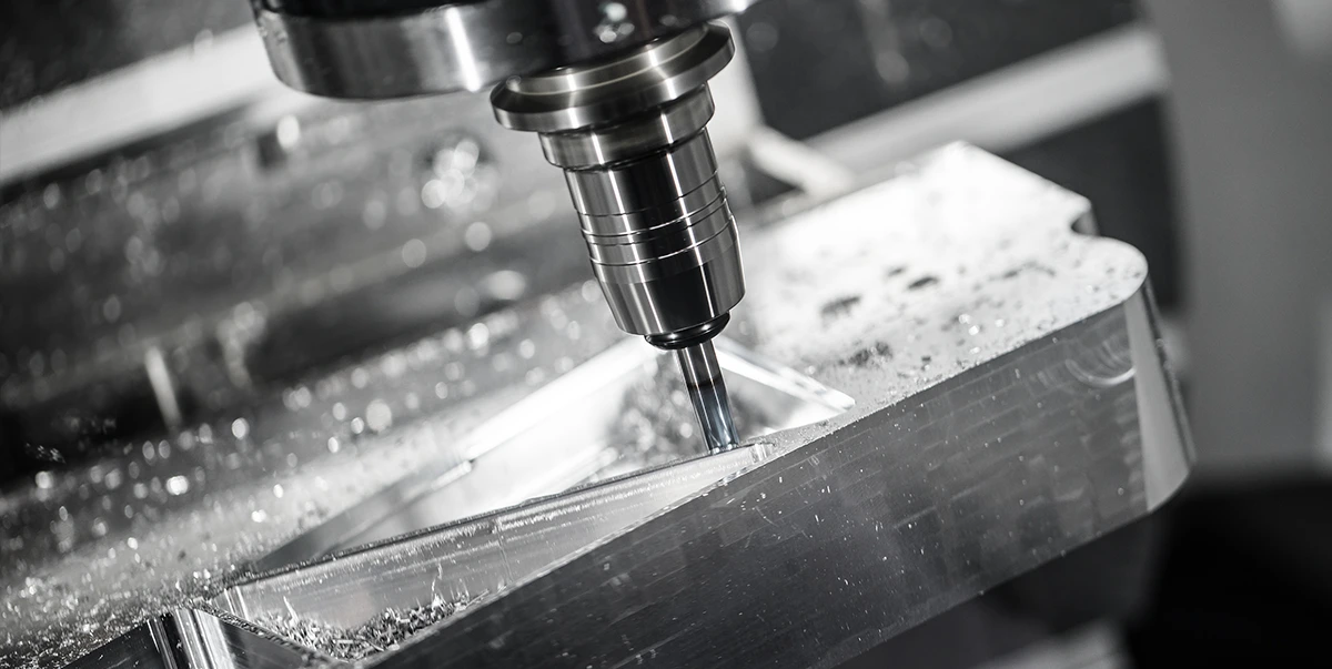 Frezowania kawałka metalu w kształcie  trójkąta.